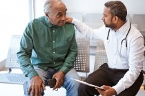 Doctor consoling sad senior male patient